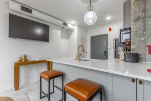 a kitchen with a sink and a counter with stools at Park Hotel 1BR Suite 402 in Chattanooga