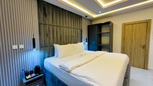 a bedroom with a large white bed in a room at Bayford Suites in Abuja