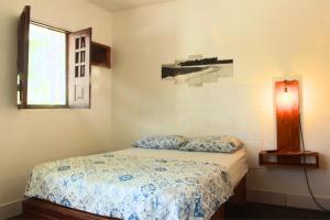 a bedroom with a bed and a window at Canto da Onda - Trilha exclusiva para a praia in Marechal Deodoro