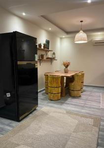 a dining room with a table and a black refrigerator at Sun capital stylish apartment in ‘Ezbet `Abd el-Ḥamîd