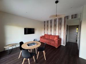 a living room with a red couch and a table at Le Buchon Lodge in Montcornet +17 photos