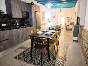 a dining room table with yellow chairs in a kitchen at El Tesoro de Cadiz in Cádiz