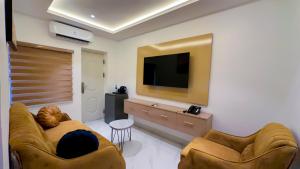 a living room with two couches and a flat screen tv at Bayford Suites in Abuja