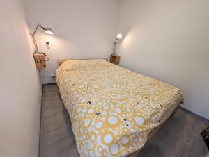 a bed in a room with two lights on the wall at La vague in Camiers