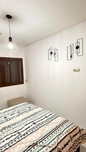 un dormitorio con una cama en una habitación blanca en appartement équipé, en Tánger