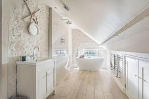 a bathroom with a white tub and a sink at Washmere House in Colerne +28 photos
