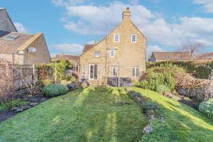 an exterior view of a large brick house with a yard at Washmere House in Colerne