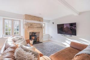 a living room with a couch and a fireplace at Washmere House in Colerne
