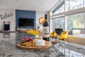a bottle of wine and a glass of wine and cheese at Pine Cone Cabin Flagstaff 3BR 2BA in Flagstaff