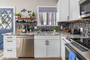 a kitchen with white cabinets and granite counter tops at Pine Cone Cabin Flagstaff 3BR 2BA in Flagstaff +46 photos
