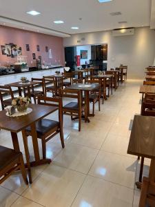 a dining room with wooden tables and chairs at Plaza Hotel in Mineiros +17 photos