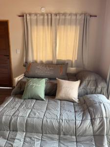 a bed with pillows on it in a bedroom at L&M Cabañas Villa Yacanto in Villa Yacanto +20 photos