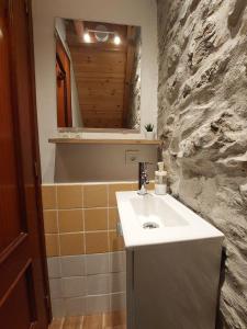 a bathroom with a sink and a stone wall at Casa Nayala in Río Aller