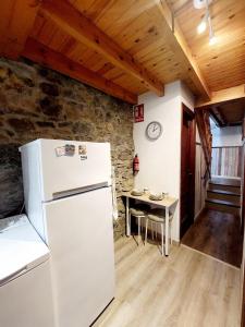 a kitchen with a white refrigerator and a table at Casa Nayala in Río Aller