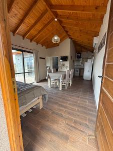 a living room with a table and a kitchen at L&M Cabañas Villa Yacanto in Villa Yacanto