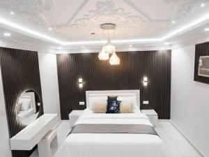 a bedroom with a large white bed and a mirror at مرافئ in Medina