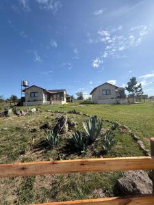 a view of a yard with houses in the background at L&M Cabañas Villa Yacanto in Villa Yacanto