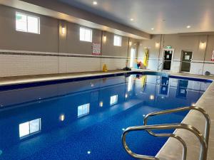 a large swimming pool with chairs in a building at Seely's Motel in Shediac