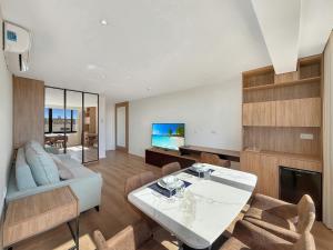 a living room with a table and a couch at Ocean Breeze Rooms, Albufeira in Albufeira