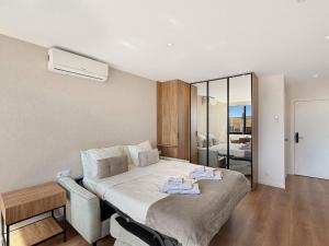 a bedroom with a large bed with a chair at Ocean Breeze Rooms, Albufeira in Albufeira