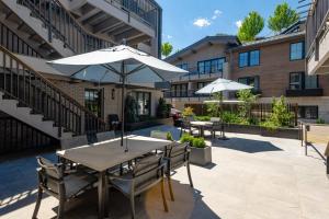 a patio with tables and umbrellas in front of a building at Chateau DuMont 05 in Aspen