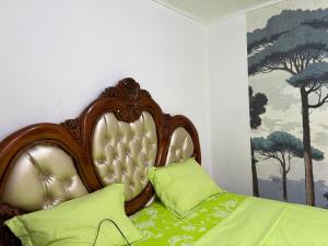 a bed with a wooden headboard in a bedroom at Villa Golden Gâte 8 Bred room in Dombé