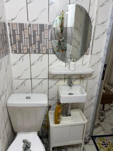 a bathroom with a toilet and a sink and a mirror at Villa Golden Gâte 8 Bred room in Dombé +56 photos