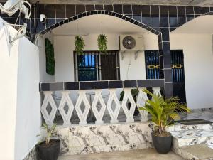 a building with two potted plants on the wall at Villa Golden Gâte 8 Bred room in Dombé