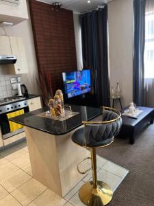 a kitchen with a black counter and a stool at Mapungubwe Diamond's hotel in Johannesburg