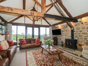 a living room with a couch and a fireplace at Corn House in Plaish