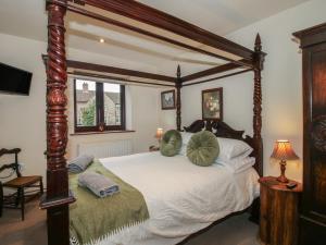 a bedroom with a canopy bed with pillows on it at Corn House in Plaish +114 photos