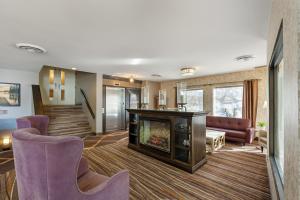 a living room with a fireplace and purple chairs at Best Western Plus Otonabee Inn in Peterborough