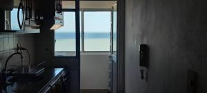 a kitchen with a door with a view of the ocean at Frente al mar in Montevideo