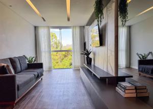 a living room with a couch and a large window at Apartamento com 2 quartos a 5 minutos do centro in Brusque