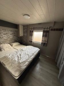 a large bed in a room with a brick wall at Blue Sea Horizon in Wenduine
