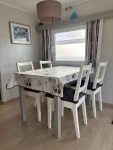 a dining room table with white chairs and a window at Blue Sea Horizon in Wenduine