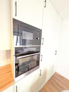 a microwave oven in a white cabinet in a kitchen at Apartament Podgórze Wałbrzych in Wałbrzych +10 photos