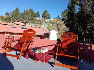two orange chairs sitting on top of a roof at Casa Amadeus in Estanciasuyo +8 photos