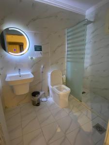 a bathroom with a toilet and a sink and a mirror at فندق منازل قباء الفندقية in Medina