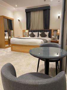 a hotel room with a bed and a table and chairs at فندق منازل قباء الفندقية in Medina