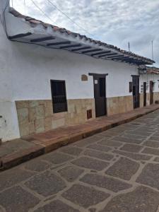 a white building with doors and windows on a street at Casa Doña Rosaura Barichara ALQUILER Entero in Barichara +10 photos