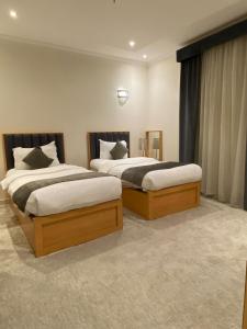 two beds in a hotel room withskirts at فندق منازل قباء الفندقية in Medina +13 photos