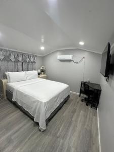 a bedroom with a large white bed and a desk at Beautiful independent suite in Brandon