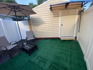 a patio with an umbrella and a table and chairs at Beautiful independent suite in Brandon