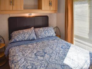 a bedroom with a bed with a blue and white comforter at Sea View in Trimingham +16 photos