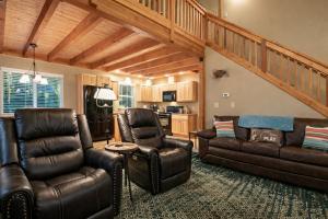 a living room with leather furniture and a staircase at Paws in the Mountains by NW Comfy Cabins in Leavenworth