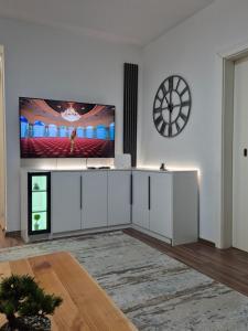 a living room with a flat screen tv on a wall at Eloi Apartment in Gjakove