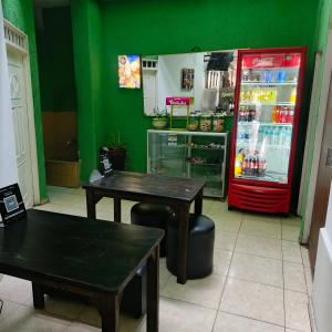 a restaurant with two tables and a red refrigerator at Hotel BSJ Neiva in Neiva