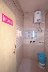 a bathroom with a toilet and a sign on the wall at Laxmi Dormitory - 2 mins walk from Prem Mandir in Vrindāvan