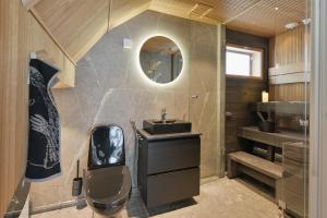 a bathroom with a sink and a toilet and a mirror at Levi Skyview Igloo in Levi +32 photos